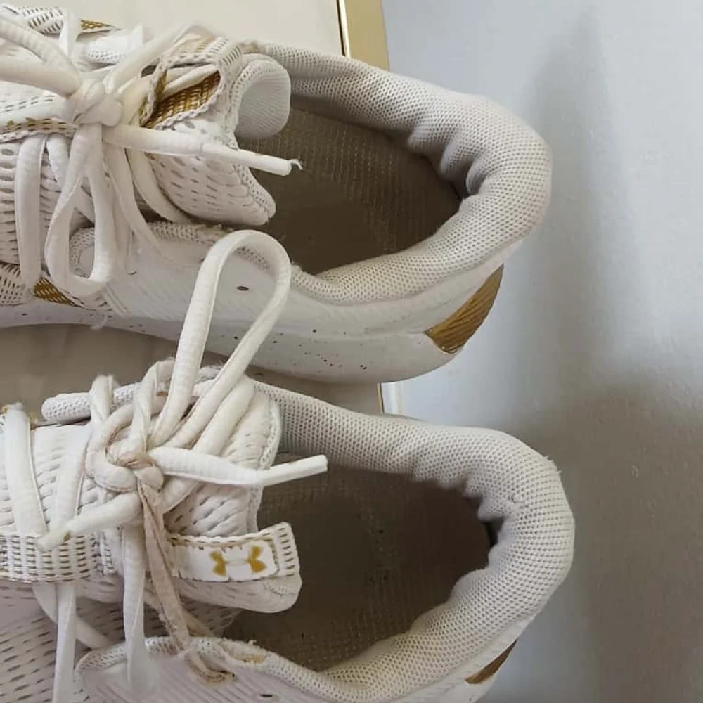 Under Armour White Sneakers with Gold Accents Size 10.